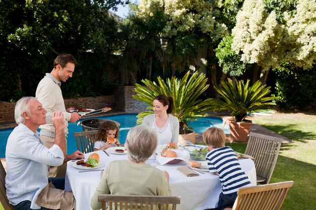 Foto familia comiendo en el jardín