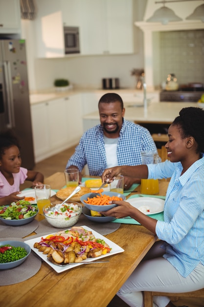 Familia comiendo en la mesa de comedor en casa