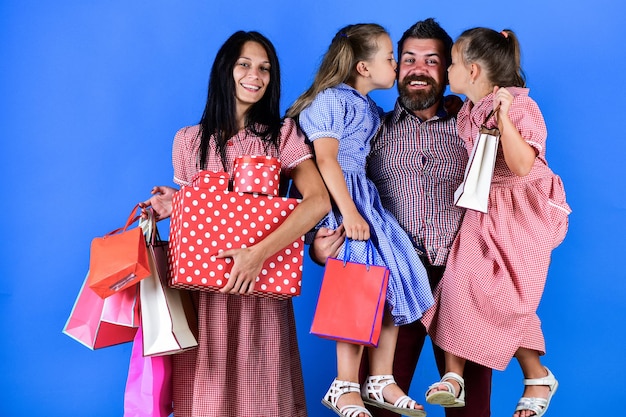 La familia va de compras. madre padre e hijos con paquetes. celebrando las fiestas juntos. back friday y cyber monday. buena compra. comprar ropa en centro comercial. mamá y papá con niños. feliz dia de la familia.