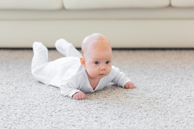 Família, conceito de infância - retrato de um bebê lindo deitado no chão