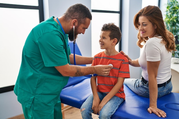 Familia con consulta médica auscultando el corazón en la clínica