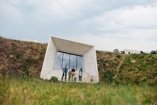 Familia contra la pared de piedra del edificio futurista moderno con ventana al aire libre