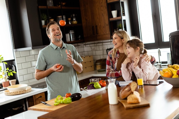 Foto família conversando e preparando comida em torno de um balcão de cozinha movimentado cheio de ingredientes frescos e utensílios de cozinha