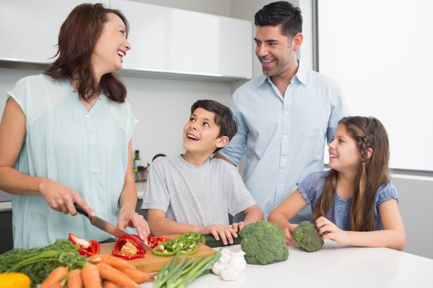 Família cortando vegetais na cozinha