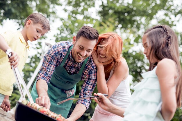 Família cozinhar churrasco no parque