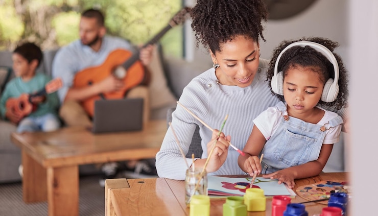 Foto família criativa mãe e menina fazendo arte e artesanato com o pai e em segundo plano com guitarra em casa pintando o desenvolvimento infantil e os pais amam as crianças uma mãe do brasil e criança com tinta