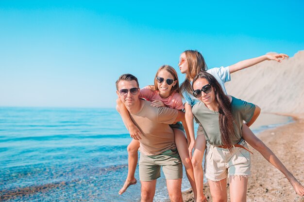 Familia de cuatro divirtiéndose juntos en la playa