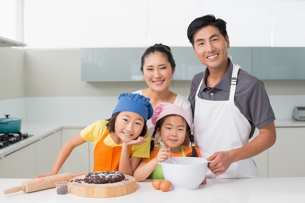 Familia de cuatro personas preparando galletas en la cocina