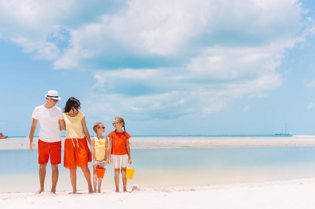 Familia de cuatro en una playa tropical