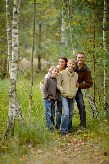 Familia de cuatro posando en el bosque de otoño