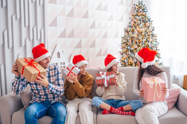 Familia de cuatro con regalos de Navidad en casa