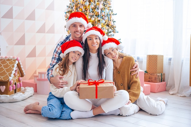 Familia de cuatro en vacaciones de Navidad en casa. Feliz Navidad y Felices Fiestas.