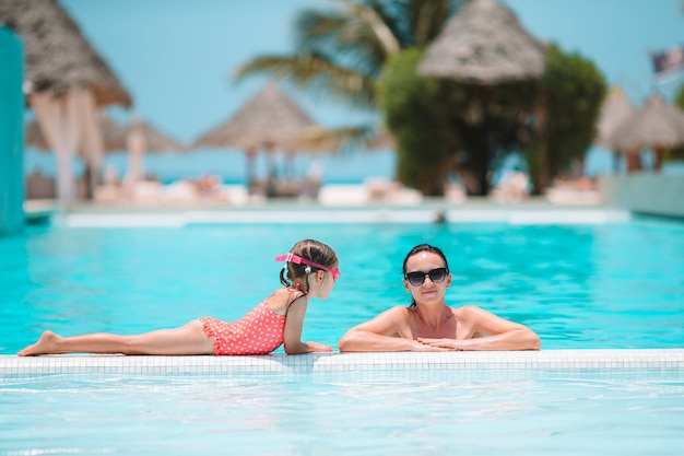 Família curtindo férias de verão na piscina de luxo