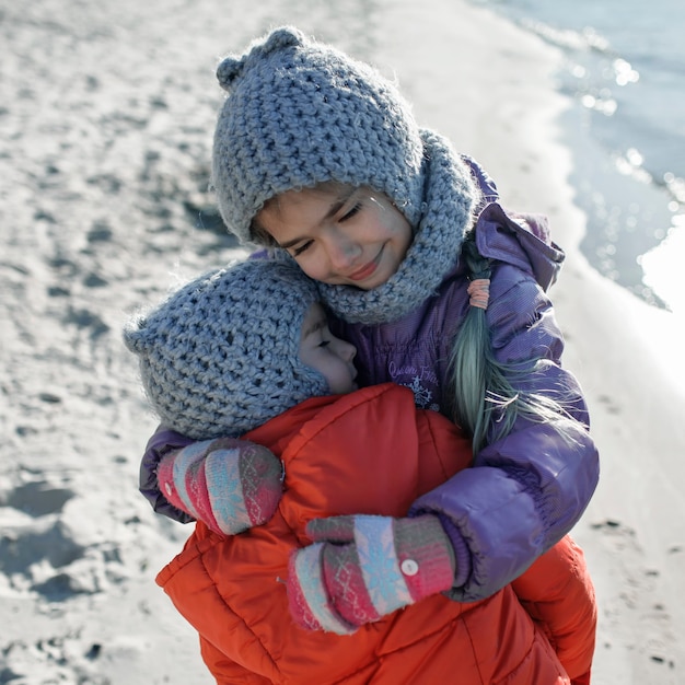 Família curtindo o inverno junta, crianças caminhando na praia no inverno