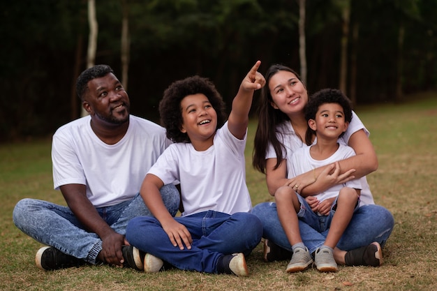 Família da diversidade com pai afro e mãe japonesa. linda família feliz no parque