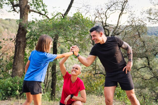 Familia dando entrenamiento de alto cinco en el bosque