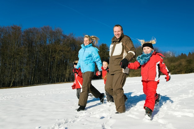 Familia dando un paseo en la nieve