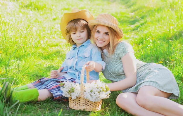 Família de jardineiro alegre sentado durante um piquenique no jardim jovem família sorridente relaxando no dia ensolarado