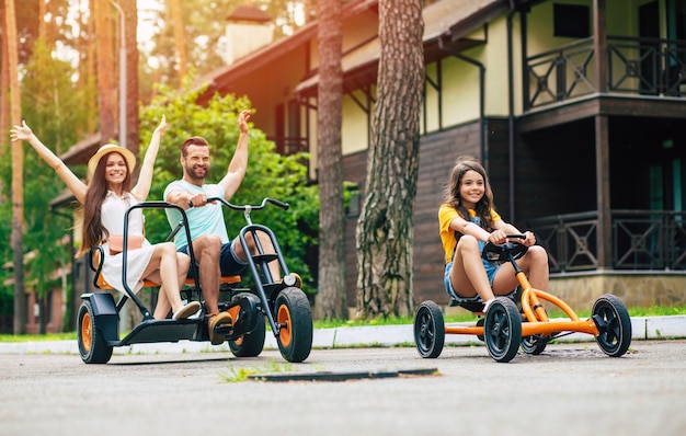 Família de jovem turista moderna e feliz de férias, andando de bicicleta e se divertindo juntos