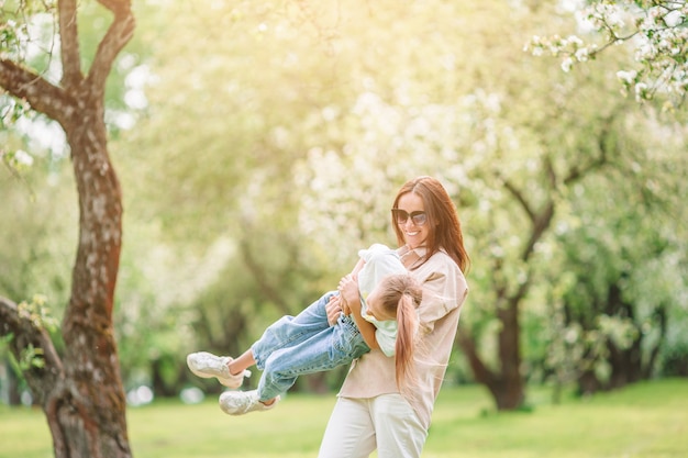 Família de mãe e filha no jardim florescendo cereja