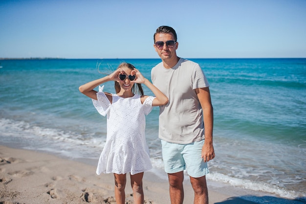 Família de pai e filha se divertem juntos na praia Férias em família