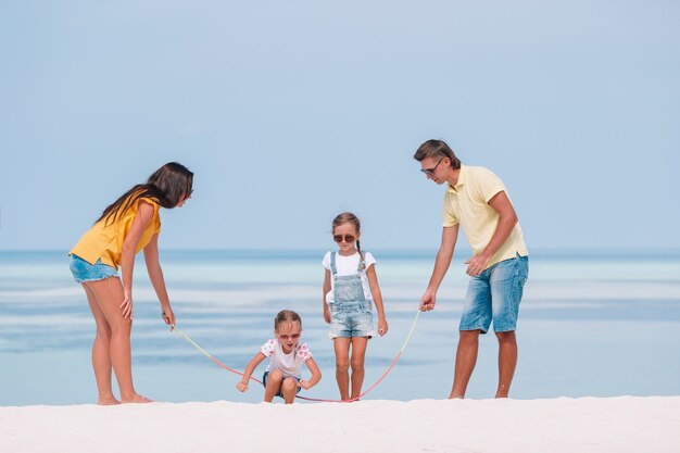 Família de quatro em férias de praia se divertir