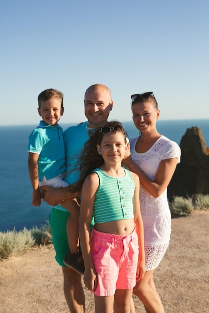 Família de quatro pessoas feliz andando nas montanhas conceito de família viagem em família