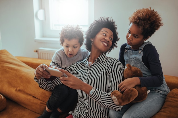 Família de quatro três tecnologia moderna em casa