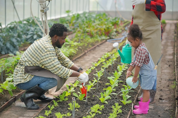Família de raça mista com filha passando tempo juntos na fazenda orgânica família afro-americana
