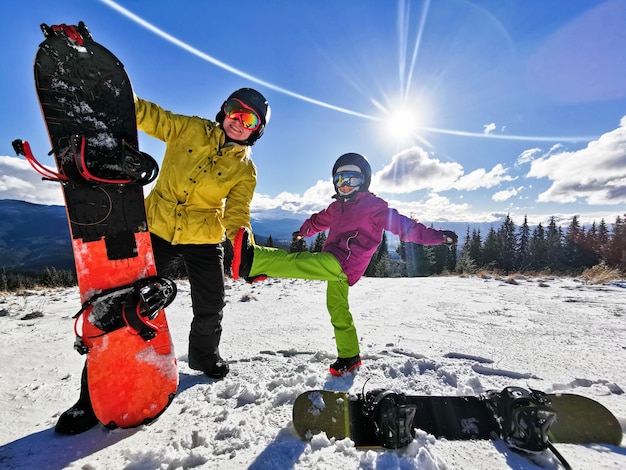 família de snowboarders em resort de inverno nas montanhas