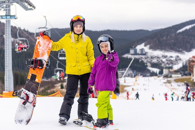 família de snowboarders em resort de inverno nas montanhas