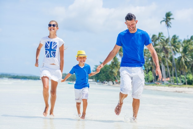 Família de três - pai com filho se divertindo na praia