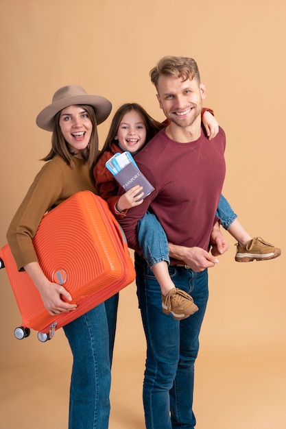 Família de três pessoas pronta para uma viagem de férias com bagagem