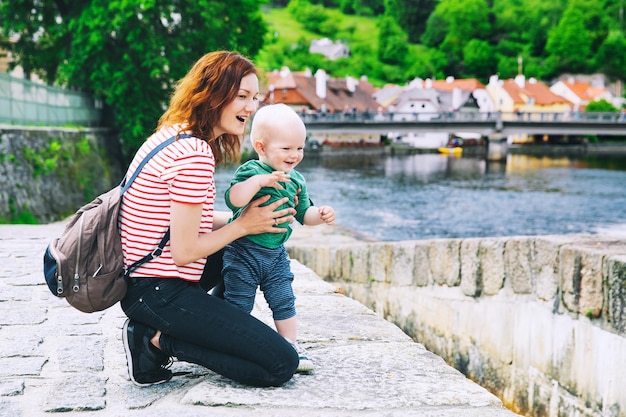 Família de turistas em cesky krumlov república checa mãe e filho caminhando perto do rio vltava