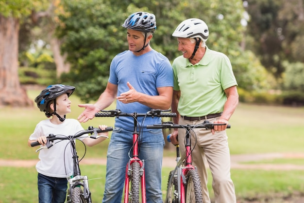 Foto família de várias gerações feliz em sua bicicleta no parque