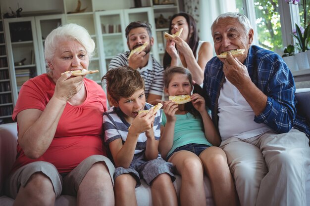 Família de várias gerações, tendo pizza juntos
