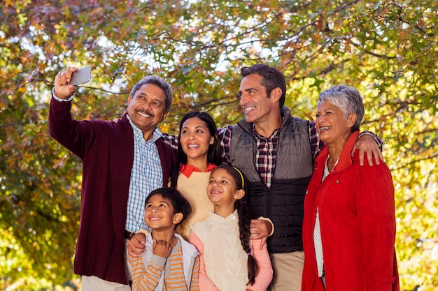 Família de várias gerações, tendo selfie no parque