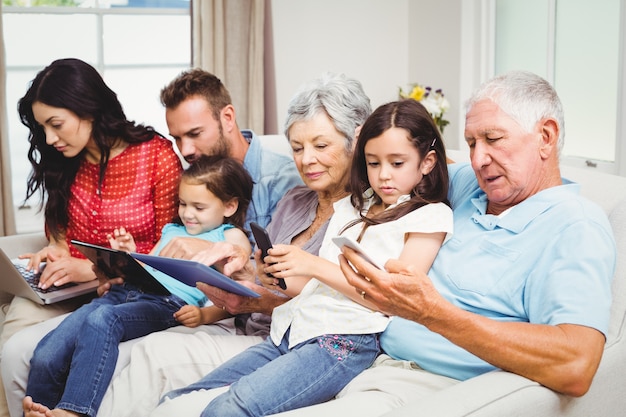 Família de várias gerações usando dispositivos tecnológicos