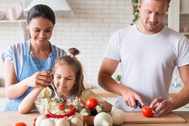 Família de vista frontal cozinhando juntos