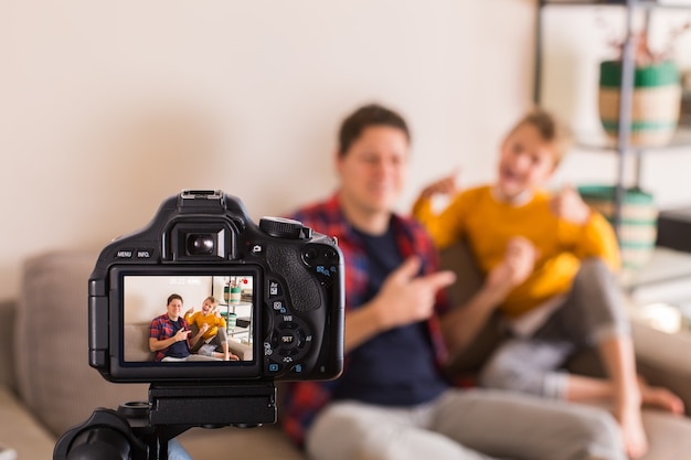 Família de vloggers gravando vídeo de mídia social enquanto está sentado no sofá