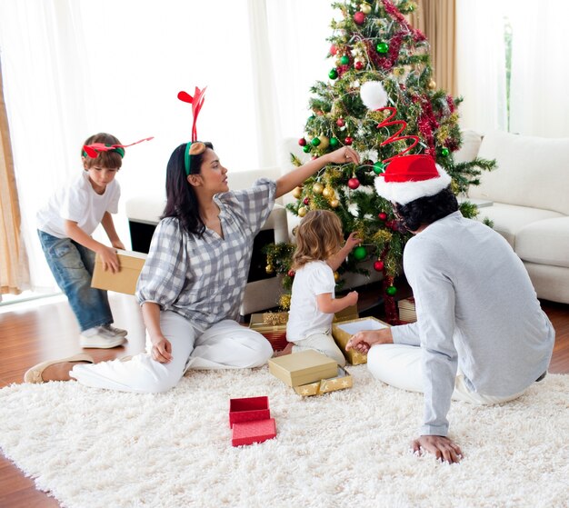 Familia decorando un árbol de Navidad