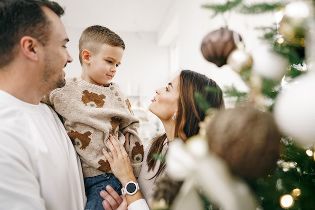 Familia de decorar un árbol de navidad en casa