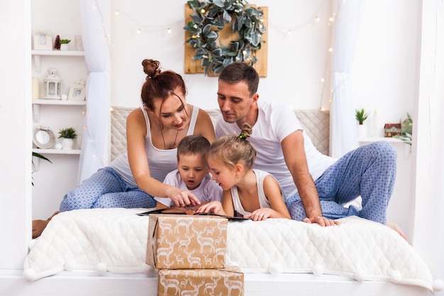 Família deitada na cama. Conceito de Natal e ano novo de férias de inverno