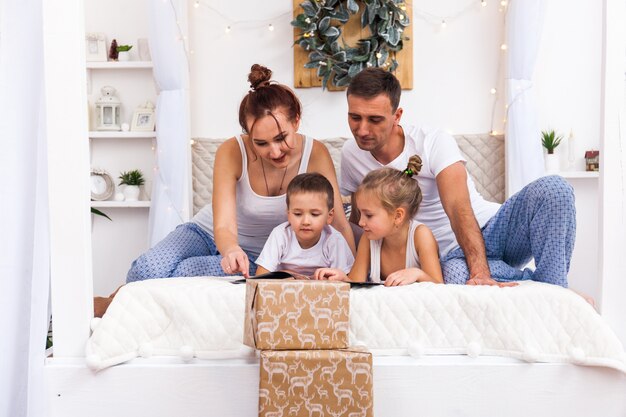 Família deitada na cama. Conceito de Natal e ano novo de férias de inverno