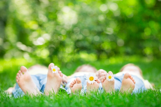 Família deitada na grama ao ar livre no parque primavera