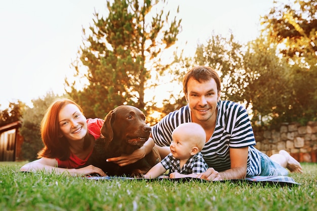 Família deitada na grama do parque em um dia de primavera e verão