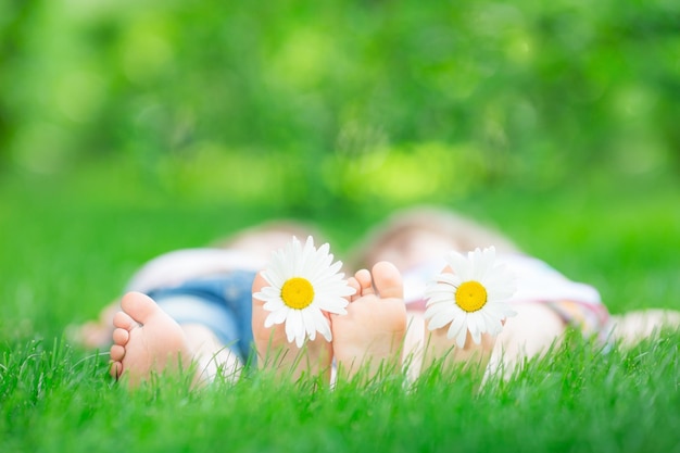 Família deitada na grama verde Crianças se divertindo ao ar livre no parque primavera