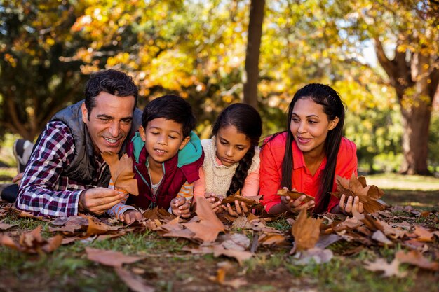 Família deitado no campo no parque durante o outono