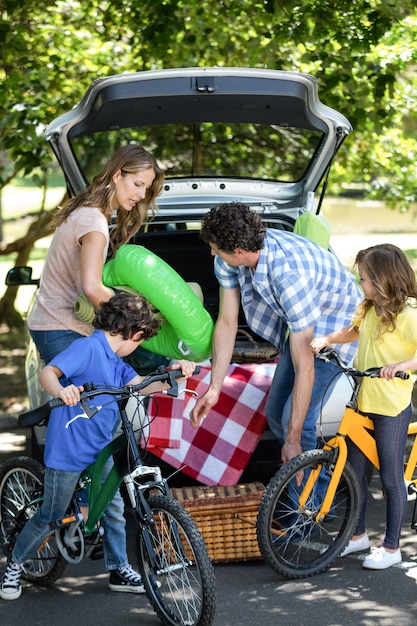 Familia delante de un coche