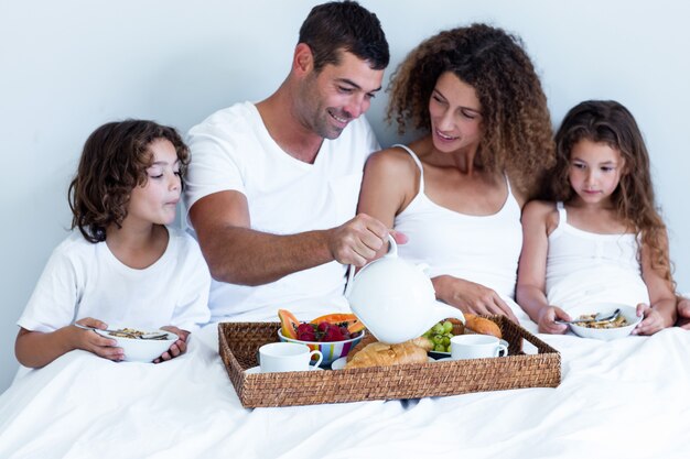 Familia desayunando en la cama